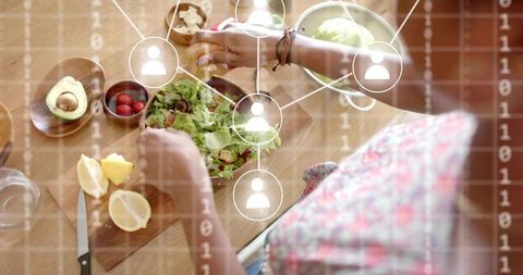 Woman Preparing Salad with Digital Network Overlay in Kitchen