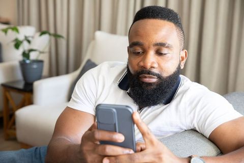 Relaxed Man Using Smartphone at Home
