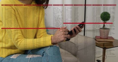 Woman holding smartphone and scrolling on sofa in modern living room with data overlay