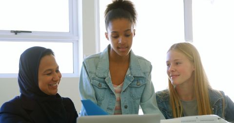 Diverse Female Group Collaborating on Laptop in Classroom