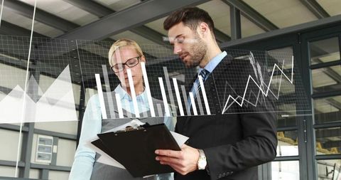 Business professionals reviewing reports and analyzing financial charts with data overlay