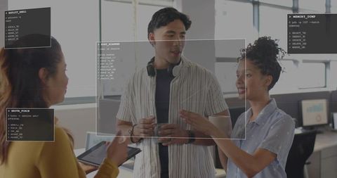 Young professionals collaborating on cybersecurity project in office with HUD overlay