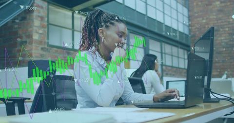 Young professional analyzing financial charts on laptop in modern coworking office