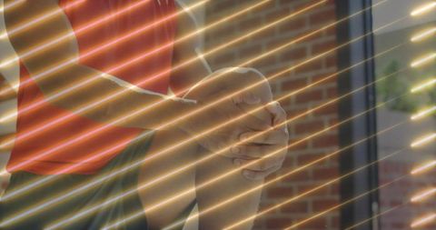 Man sitting in sunlit room holding knee for relaxation and health