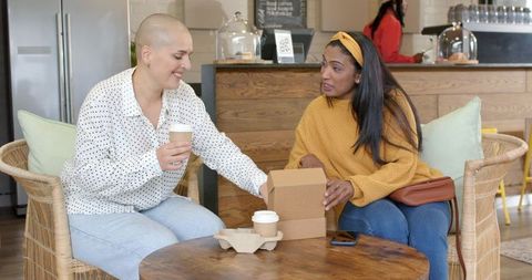 Diverse Friends Sharing Coffee and Takeaway Pastry in Cozy Coffeehouse Conversation Moment