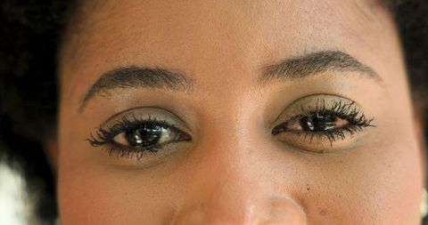 Close-up portrait of woman highlighting eye makeup and natural beauty