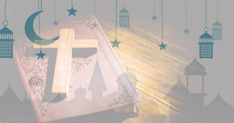 Interfaith harmony montage with wooden cross on embossed book and crescent lantern silhouettes