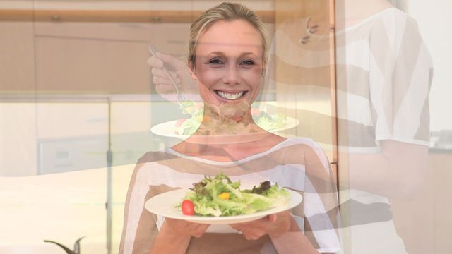 Woman enjoying the aroma of a fresh salad in a modern kitchen, smiling with happiness. Perfect for themes of healthy eating, nutrition, healthy lifestyle, wellness, and home cooking promotions.