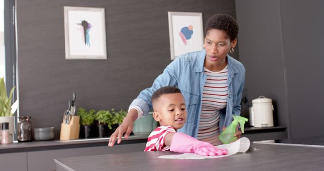 Mother Supervising Her Young Son Cleaning Kitchen Counter - Download Free Stock Images Pikwizard.com