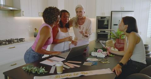 Friends planning wedding celebration with happily discussing in kitchen