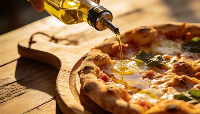 Golden olive oil drizzling over neapolitan pizza on rustic wooden peel