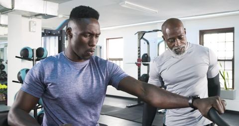 Focused African American Trainer and Trainee Exercise in Gym