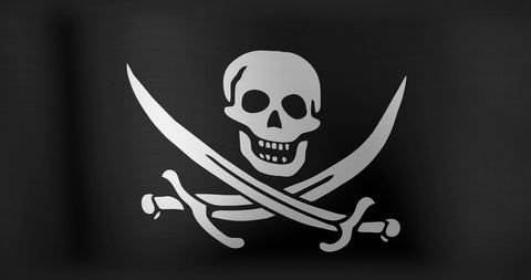 Iconic pirate jolly roger flag with skull and crossed swords waving