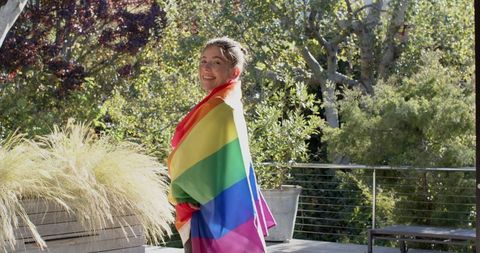 Woman Celebrating Diversity Outdoors with Rainbow Flag