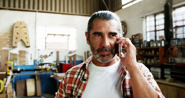 Mature Carpenter Conversing on Smartphone in Woodworking Workshop - Download Free Stock Images Pikwizard.com