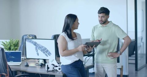 Colleagues Discussing Tech Design in Modern Office Environment