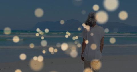 Elderly Woman Enjoying Tranquil Beach with Ethereal Lights