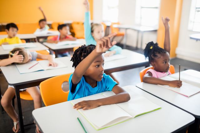 Pupils raising their hands in classroom