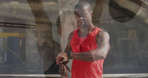 Runner in Red Tank Top Checking Smartwatch in Urban Setting