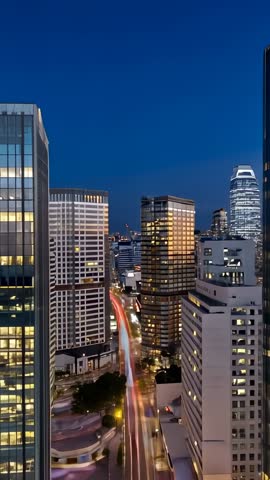 Tilting Skyline Vertical Video Showing Skyscrapers and Red Light Trails in Downtown Dusk