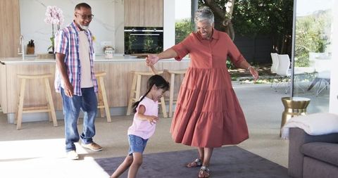 Happy Grandparents Playing with Grandchild in Bright Modern Kitchen