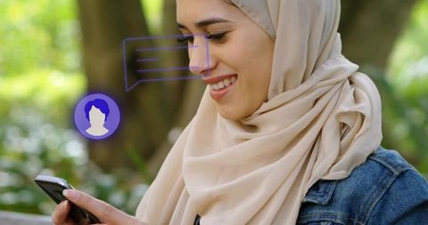Hijab-Wearing Woman Texting on Park Bench in Peaceful Environment