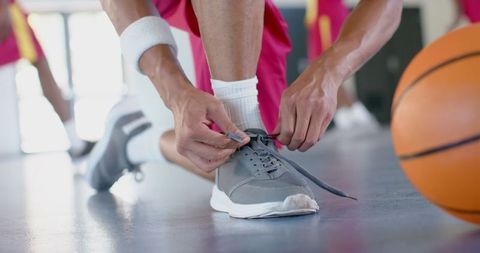 Basketball Player Tying Shoelaces on Indoor Court Before Game - Download Free Stock Images Pikwizard.com