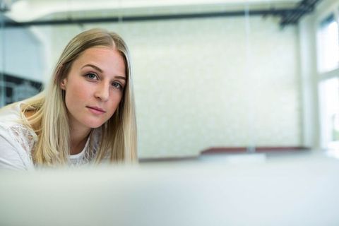 Young professional working on laptop in modern office setting