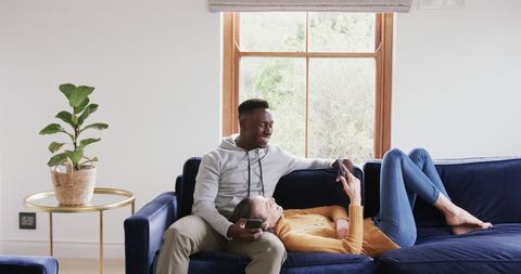 Diverse Couple Relaxing with Smartphones on Cozy Sofa - Download Free Stock Images Pikwizard.com