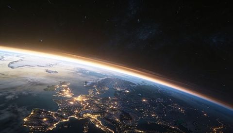 Europe at night from low earth orbit, city lights glowing along golden atmospheric limb