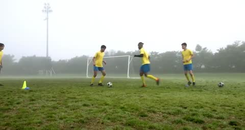 Young Soccer Players Practicing on Foggy Field with Intensity