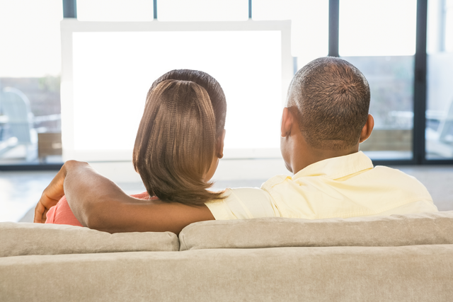 Casual Couple Relaxing on Sofa Watching Transparent TV Screen at Home - Download Free Stock Videos Pikwizard.com