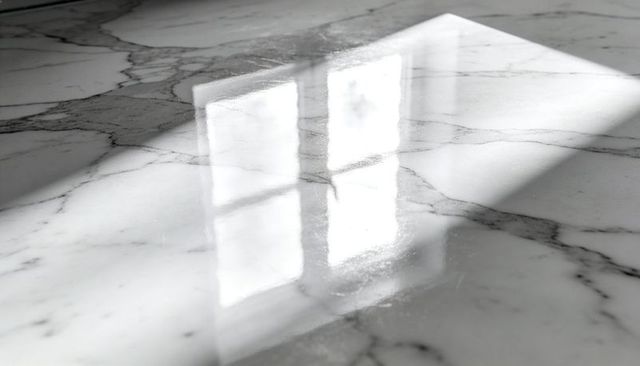 Polished white marble countertop reflecting multi-pane window light with sunlit patch