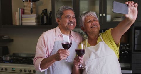 Senior Couple Toasting with Wine in Kitchen Selfie Moment