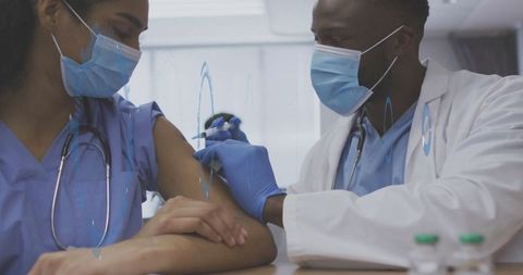 Doctor Administering Vaccine to Nurse in Medical Setting