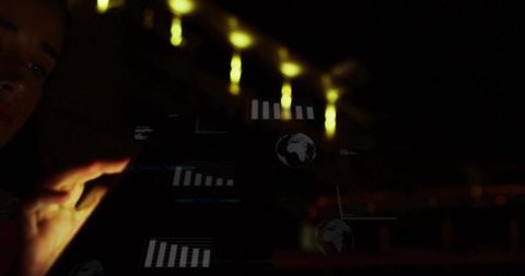 Reaching hand touching holographic data interface in dim lab, globe and bar charts