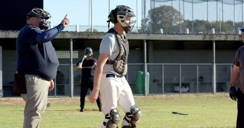 Umpire Calling Strike While Catcher Wearing Protective Gear at Community Baseball Field
