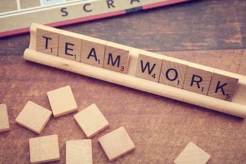 Scrabble Tiles Forming the Word Teamwork on Wooden Board