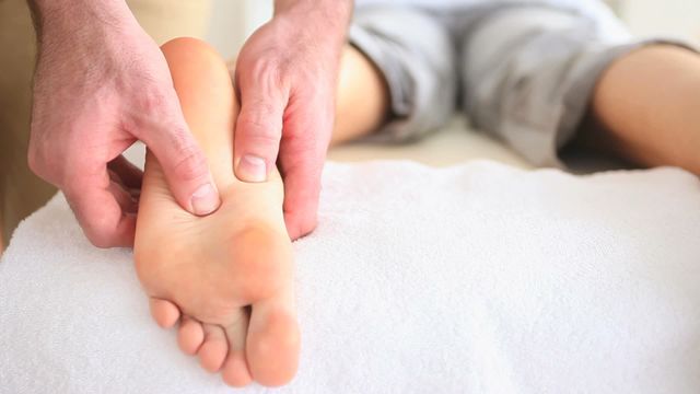 Detailed video of hands performing a reflexology foot massage in a calming wellness spa environment. Useful for articles on relaxation techniques, wellness blog posts, spa advertisements, or health treatment guides.