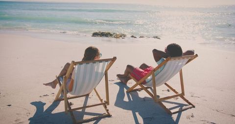 Couple Relaxing on Sunny Beach in Wooden Chairs by the Sea - Download Free Stock Images Pikwizard.com