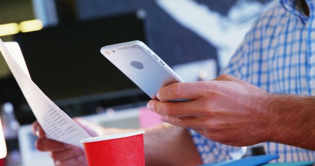 Person Using Smartphone While Holding Document in Modern Office - Download Free Stock Images Pikwizard.com