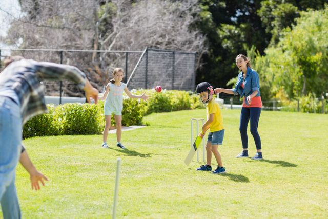 Family playing cricket in backyard on a sunny day. Children and adults enjoying outdoor sports activity, promoting family bonding and teamwork. Ideal for use in advertisements, family lifestyle blogs, and sports-related content.
