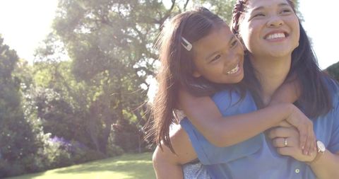 Mother Carrying Daughter on Back Embracing Outdoor Joy