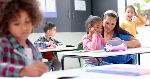 Teacher Assisting Child with Tablet in Diverse School Classroom - Download Free Stock Images Pikwizard.com