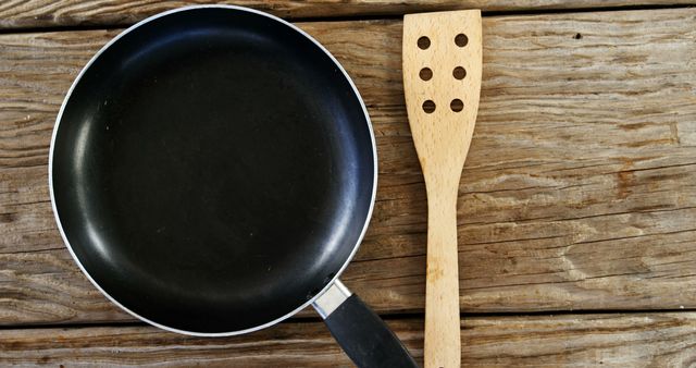 Nonstick Frying Pan and Wooden Spatula on Rustic Wooden Surface - Download Free Stock Images Pikwizard.com