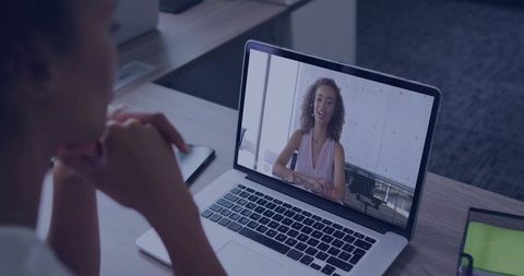 Virtual Meeting with Remote Colleague Using Laptop at Office Desk