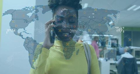 Smiling professional using smartphone in open-plan office with global network overlay