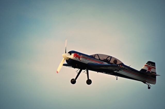 A dynamic image of a vintage stunt airplane flying through the sky, showcasing its aerobatic capabilities with a clear, propeller-focused design. Suitable for use in aviation-themed content, advertisements for air shows, educational materials about flight and aerodynamics, or publications dedicated to aviation history and enthusiasts.