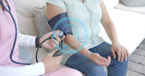 Home nurse measuring blood pressure on patient during caregiving visit with overlay