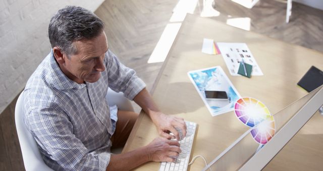 Man Working on Graphic Design Project at Desk in Bright Office - Download Free Stock Images Pikwizard.com